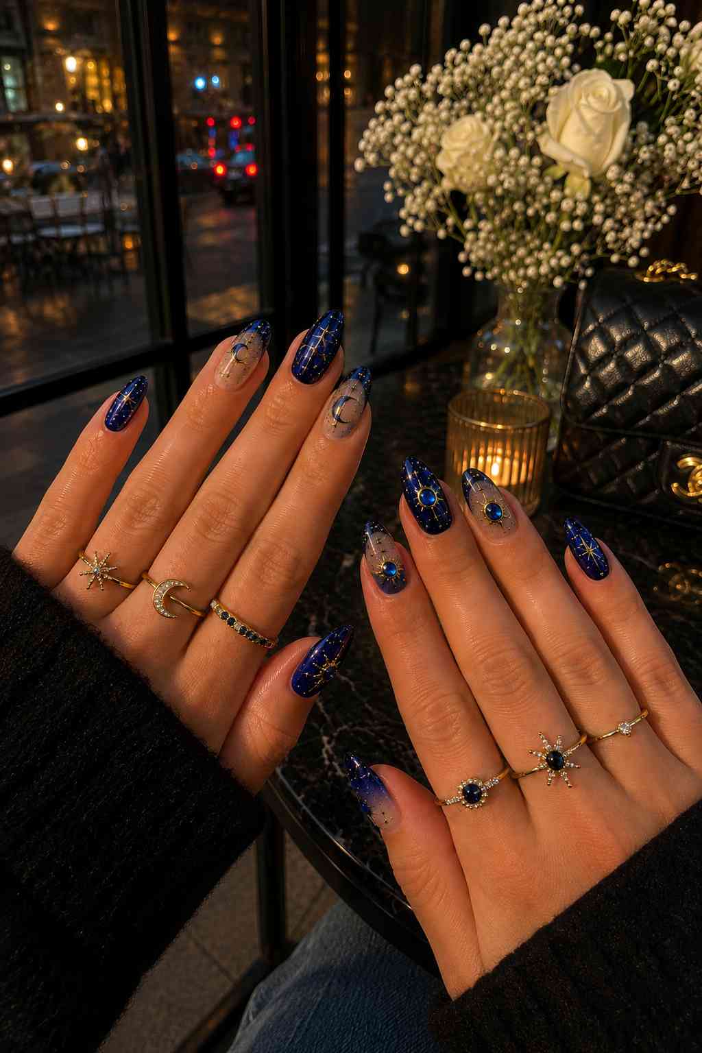 Deep navy almond nails with gold star art and sapphire gemstone centers