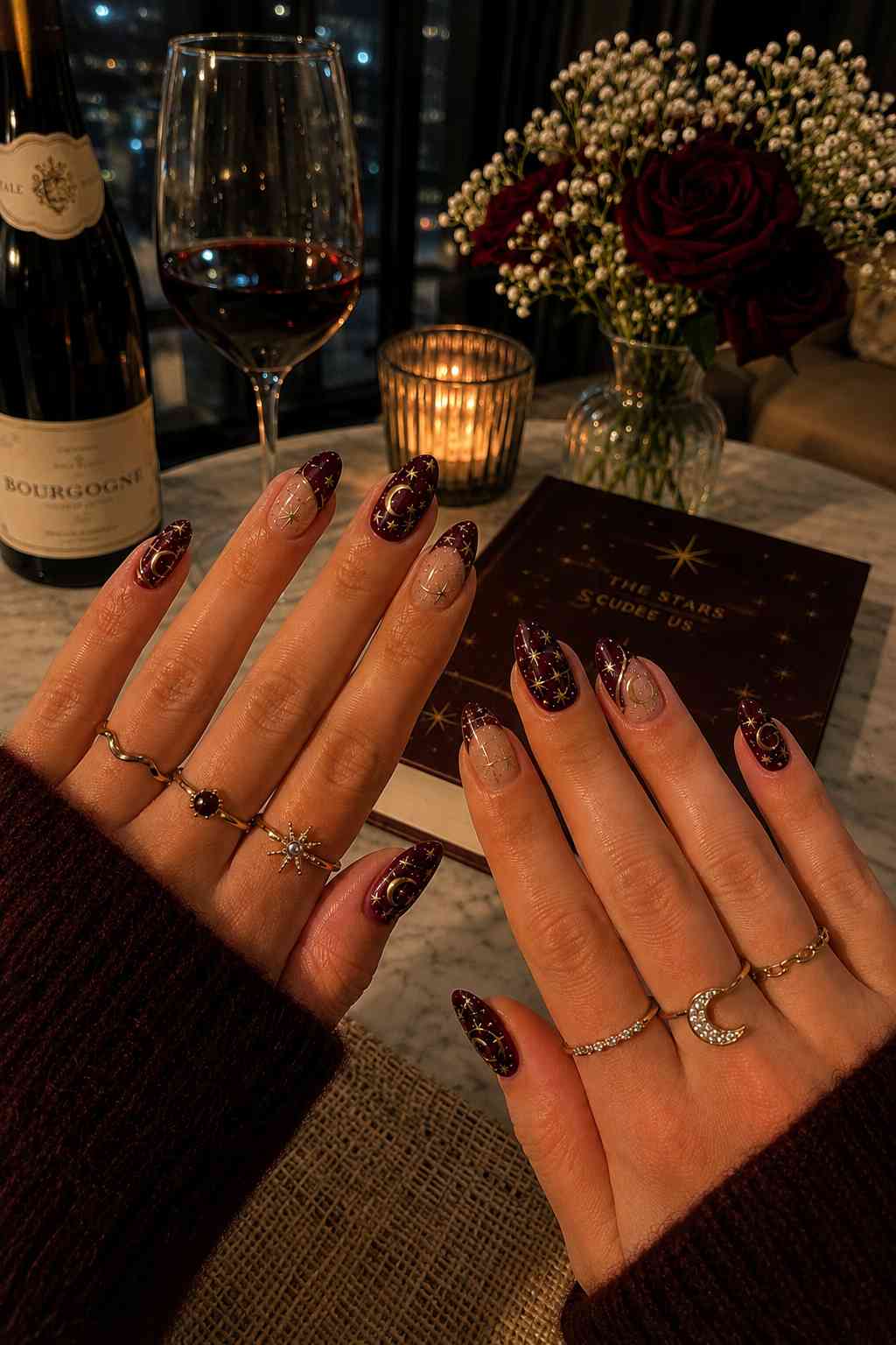 Wine red and negative space nails with gold constellation, moon, and star nail art