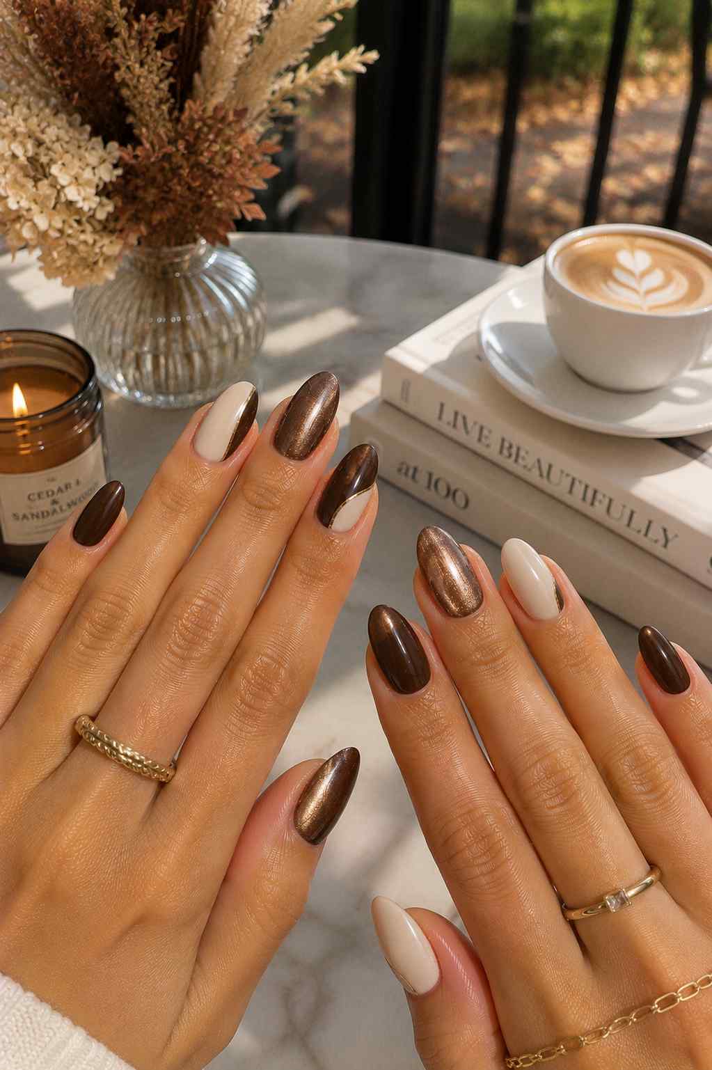 Espresso brown and milky cream color-block nails with thin gold line detailing and a bronze chrome accent nail