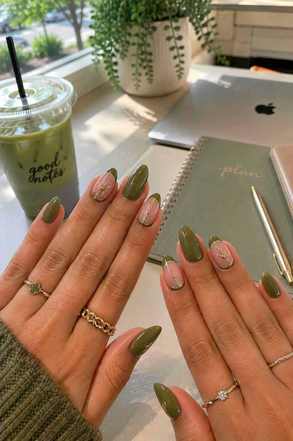 Glossy olive nails alternating with sheer nude nails featuring small gold outline flower art