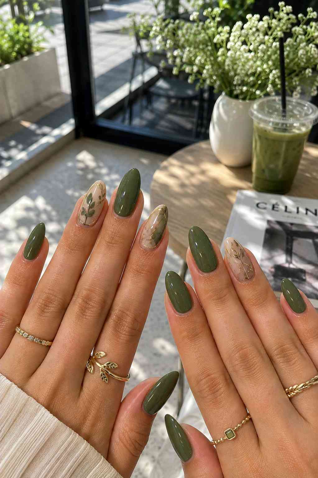 Glossy olive nails alternating with sheer nude nails featuring thin gold vine leaf art