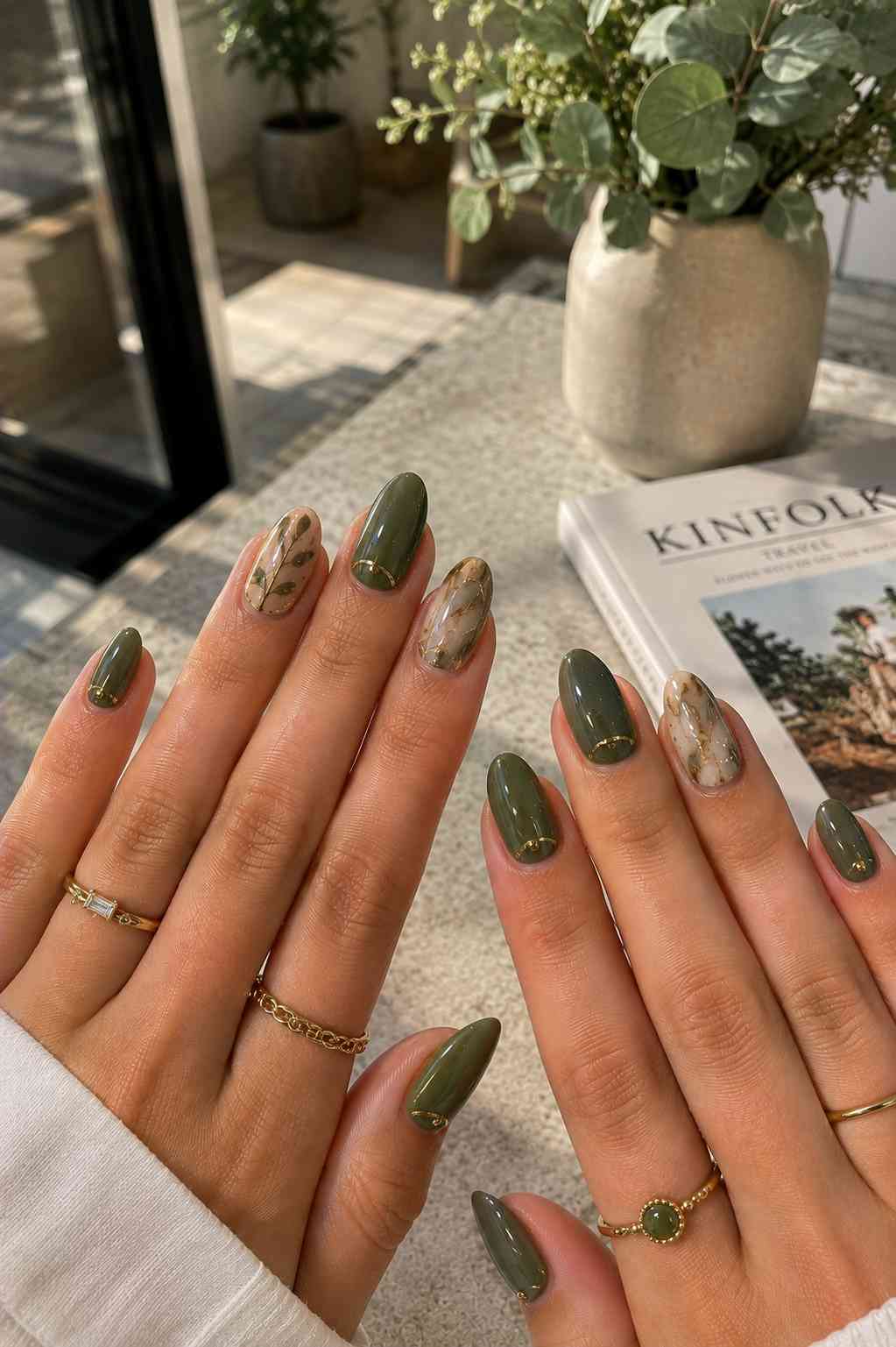 Glossy olive nails with gold cuticle lining paired with marbled gold vein and leaf branch accent nails