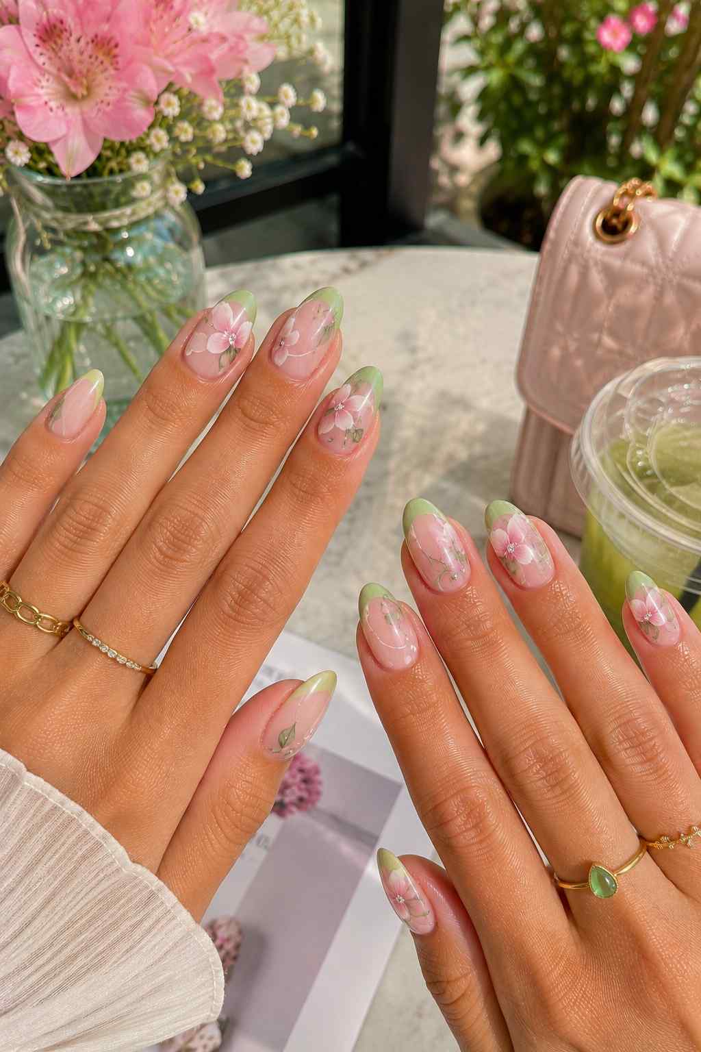 Sage green French tip nails with pressed pink floral detailing