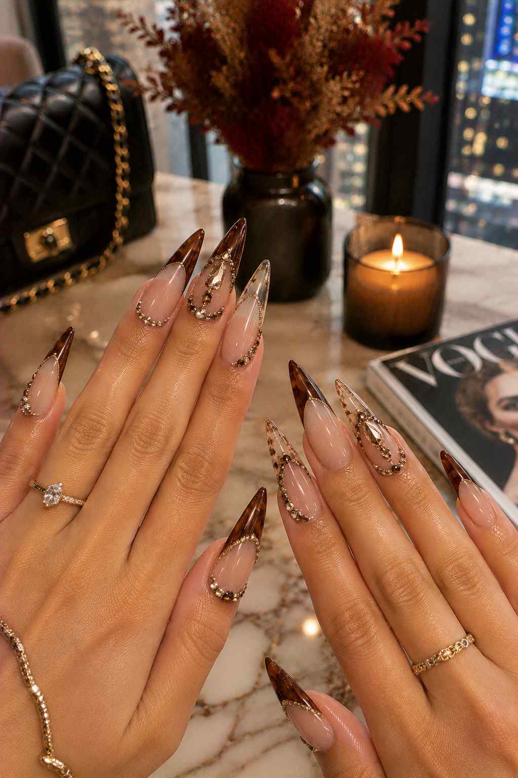 Long stiletto nails with tortoiseshell tips framed in rhinestone swirl and gem detailing