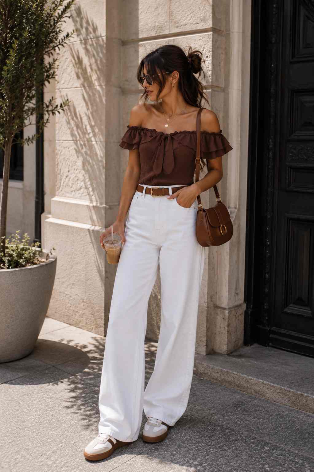 Woman wearing a ruffled-tie front top with white wide-leg jeans.