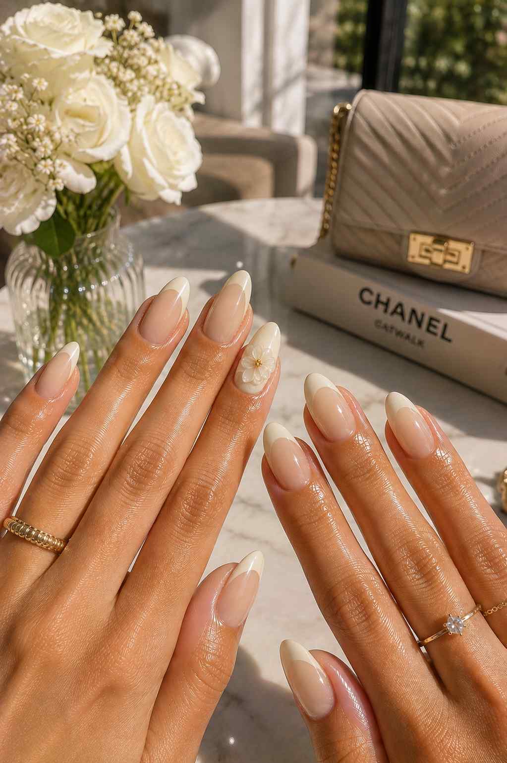Classic vanilla French tip nails with a single flower accent nail