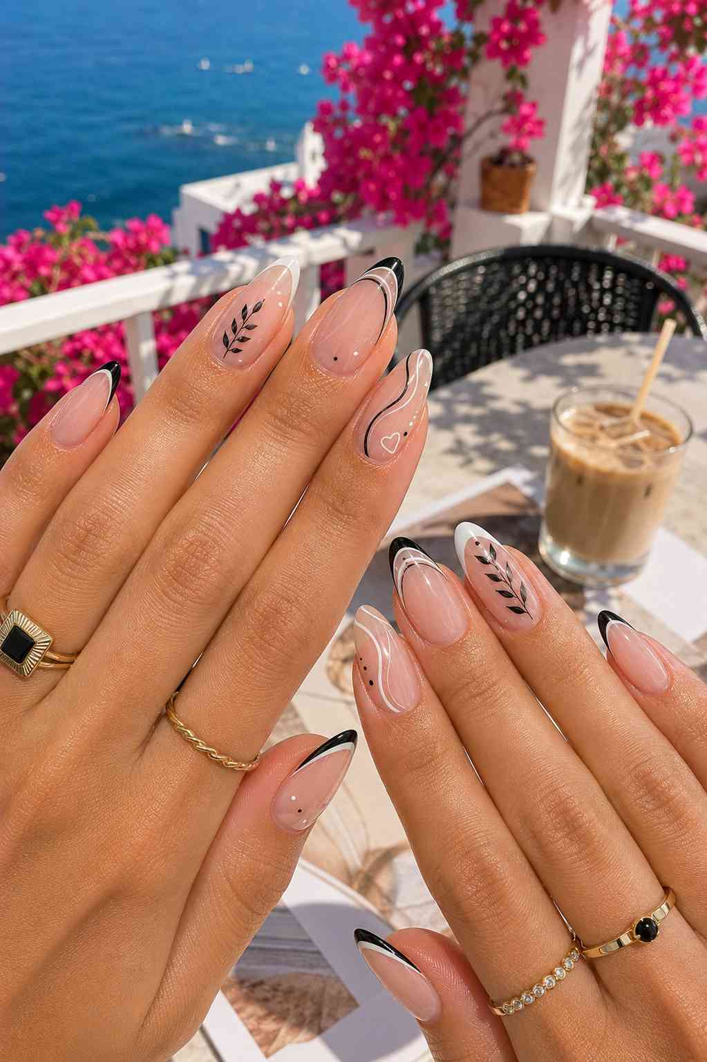 Sheer nails alternating black and white French tips with leaf branch line art, dots, and a heart accent
