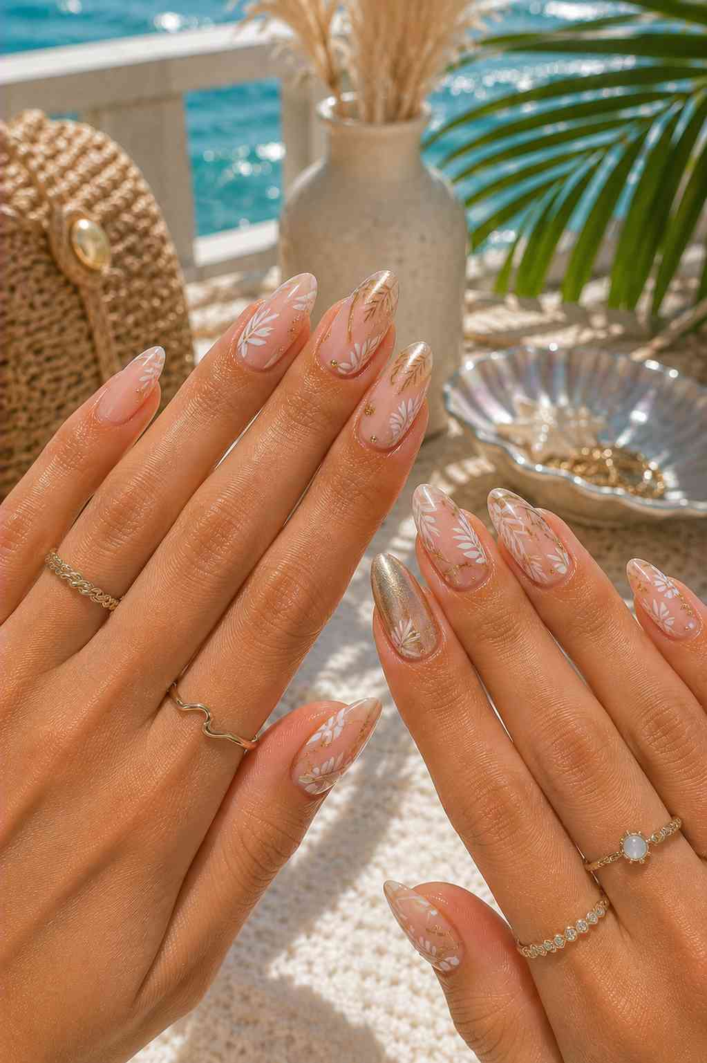 Sheer nude nails with white and gold leaf and fern line art paired with a solid gold shimmer accent nail