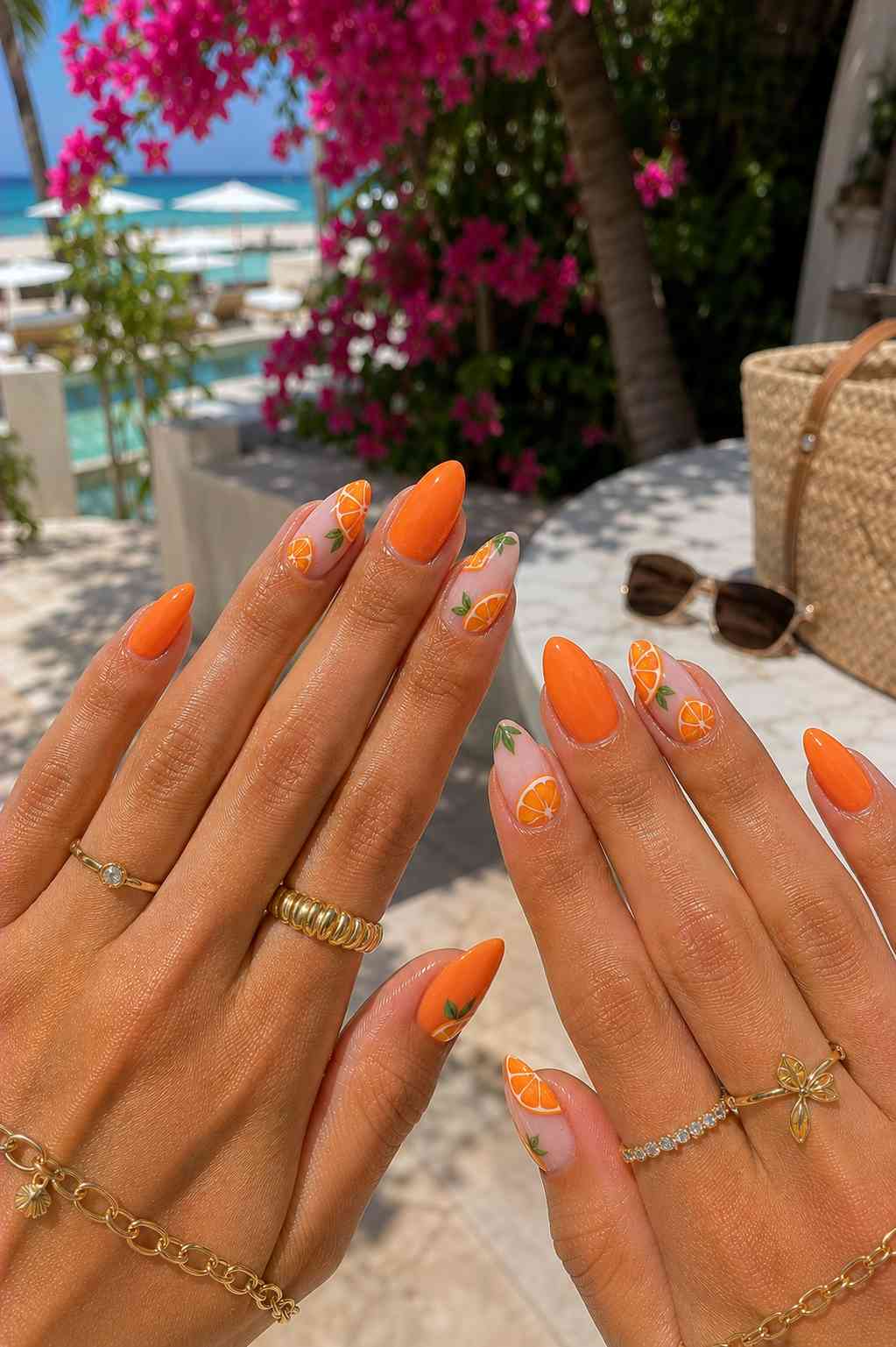 Solid orange nails with sheer accent nails featuring hand-painted orange slices and green leaves