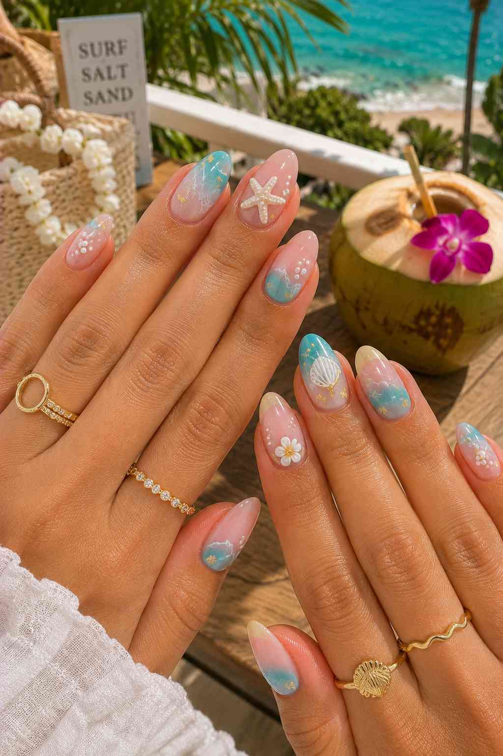 Teal cloud marbled nails with a pearl-covered starfish and small white daisies with gold flecks