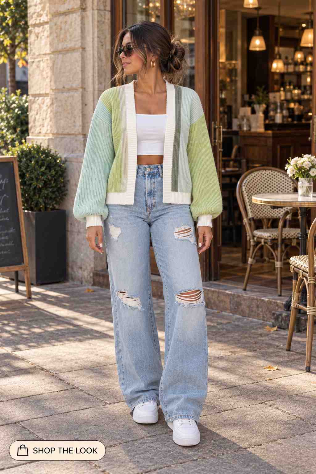 Woman in sage and mint color-block cardigan with ripped wide-leg jeans