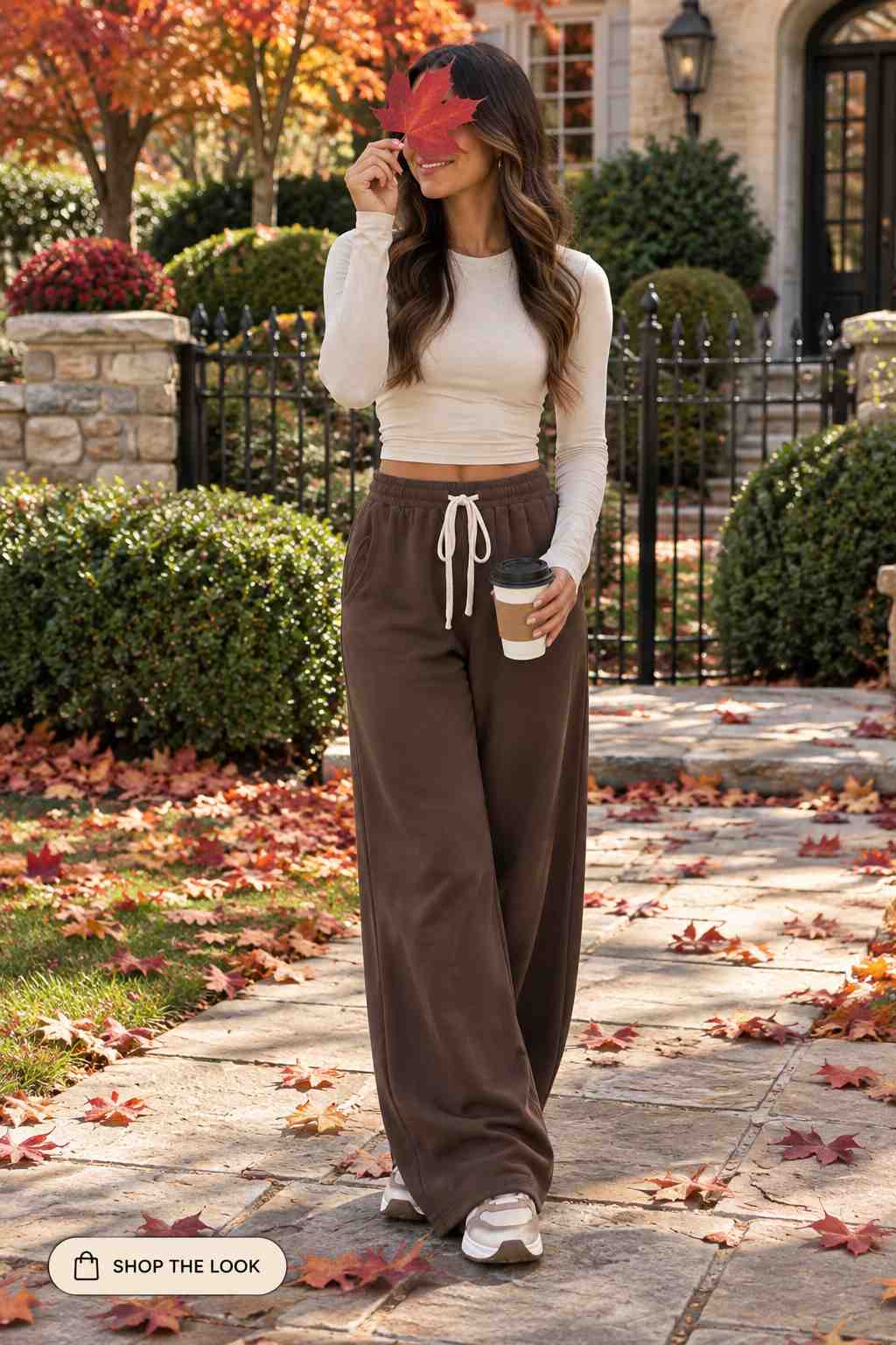 Woman in cream long sleeve crop top with brown wide-leg sweatpants and sneakers