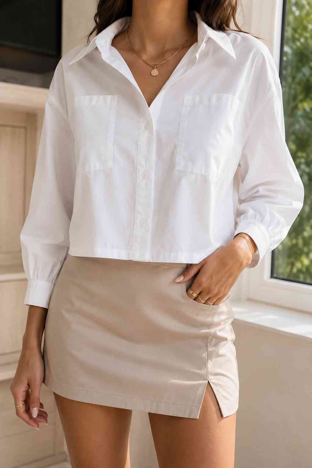 Cropped white button-up shirt with collar and patch pockets, styled with a tan mini skirt