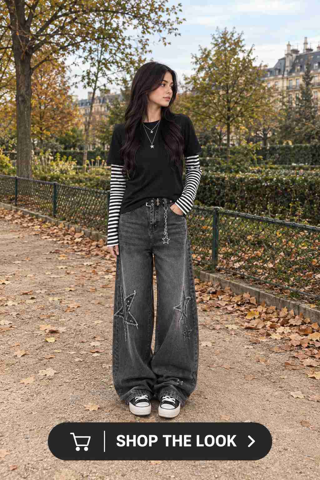 Woman in black layered tee with striped sleeves and wide-leg jeans with star patches