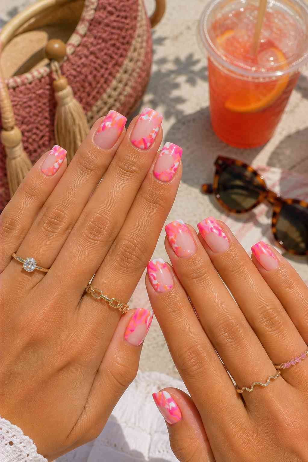 Nude nails with marbled pink and orange French tip design