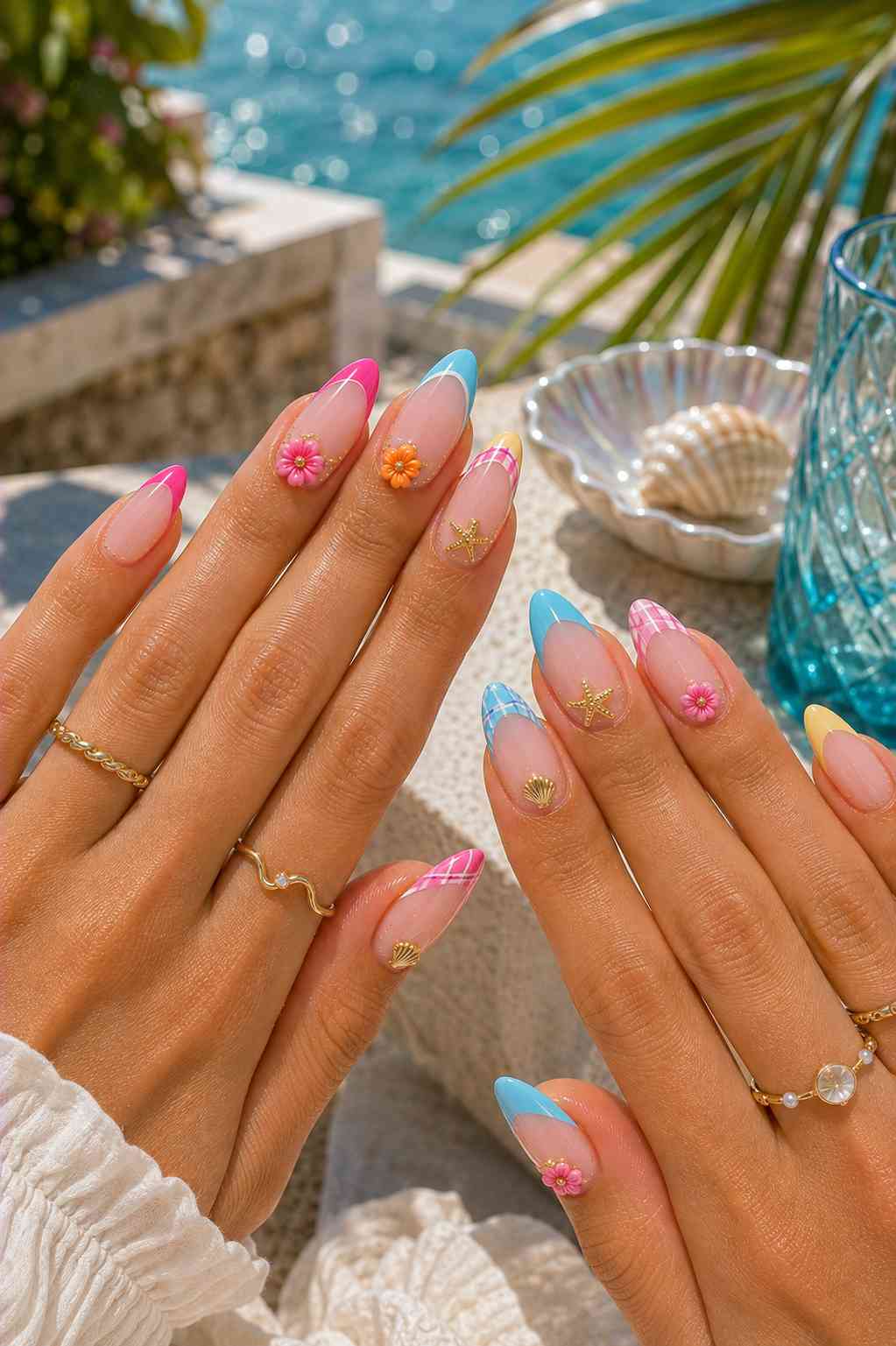 Pink, blue, and yellow French and plaid tip nails with 3D flowers, gold starfish, and shell charms