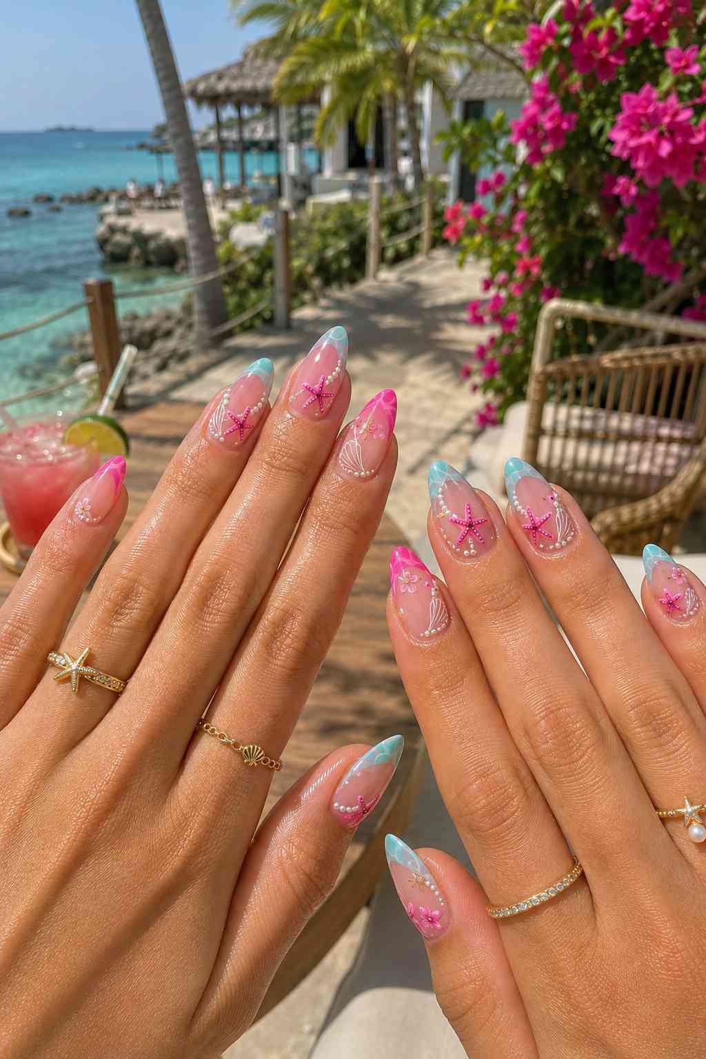 Teal and blue marbled French tip nails with pink starfish charms, pearls, and white shell line art