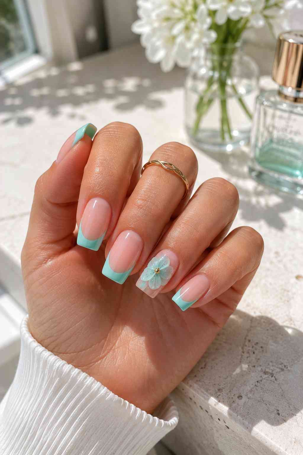 Square sheer pink nails with mint teal French tips and a translucent 3D flower accent nail