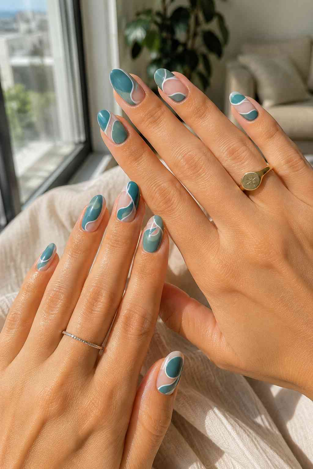 Short almond nails with muted teal and sheer nude swirls outlined with thin white lines