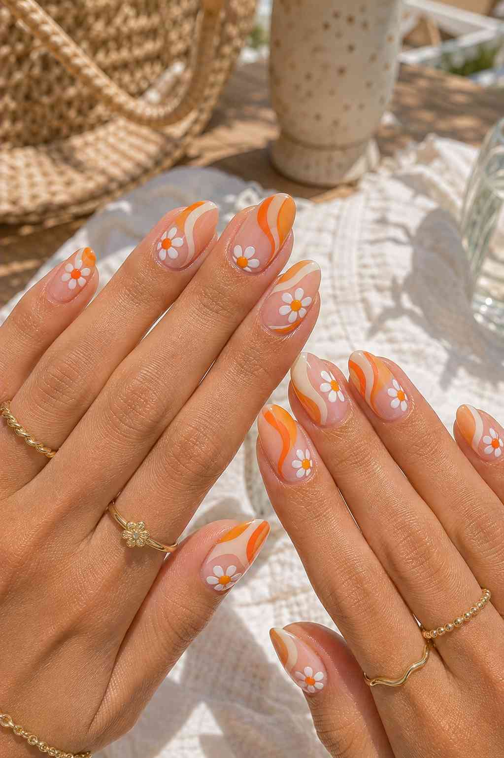 Sheer nails with wavy orange and white swirl line art and a hand-painted hibiscus flower accent