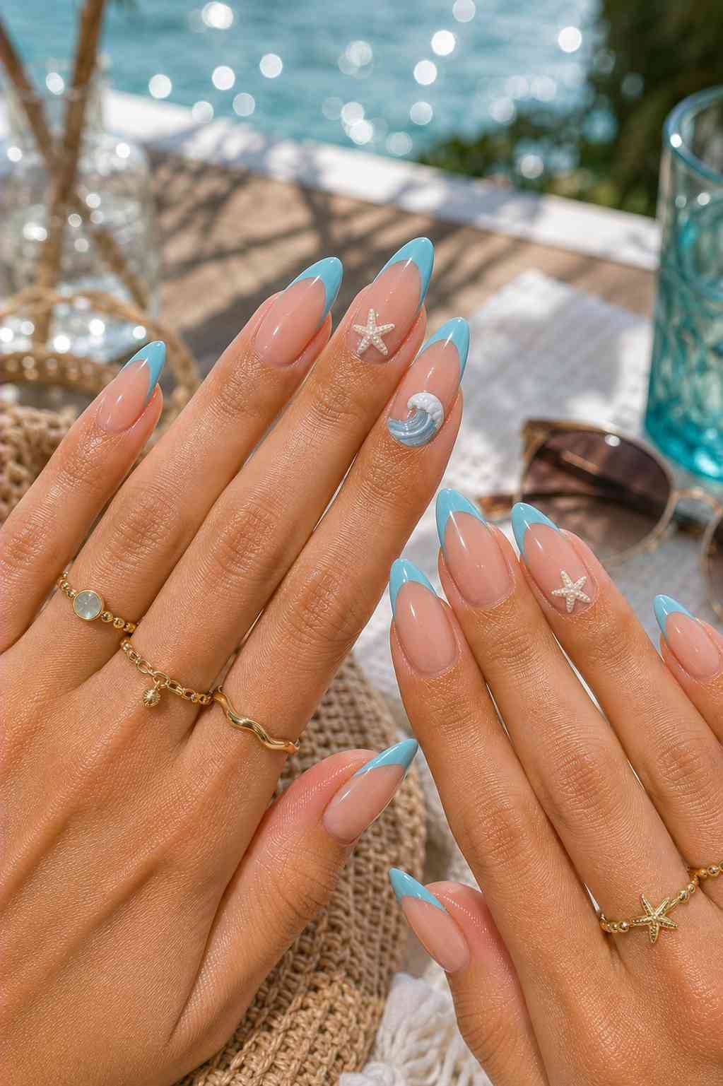 Light blue French tip nails with a small 3D starfish and wave detail accent