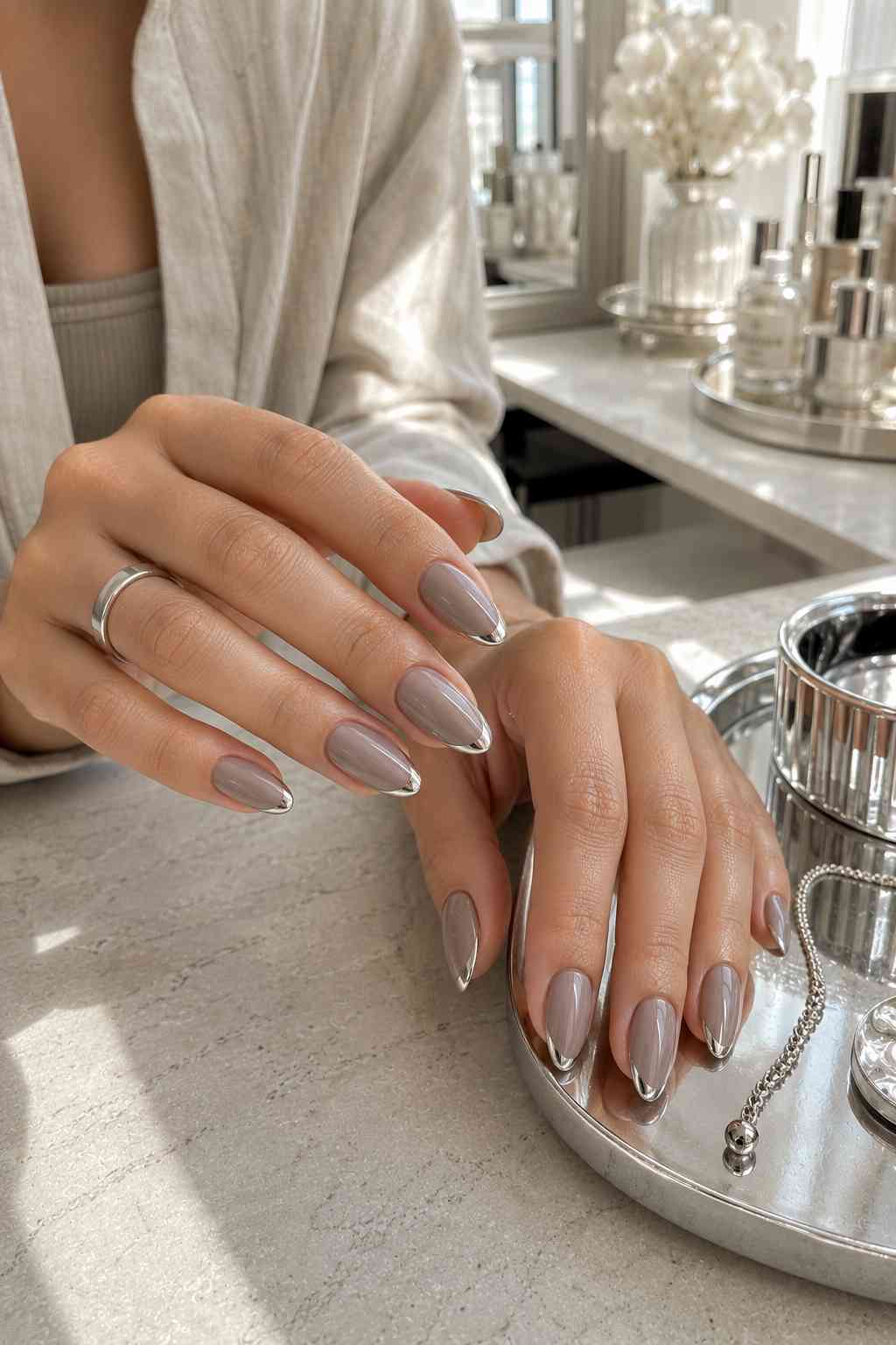 Taupe nails with metallic silver chrome French tip design