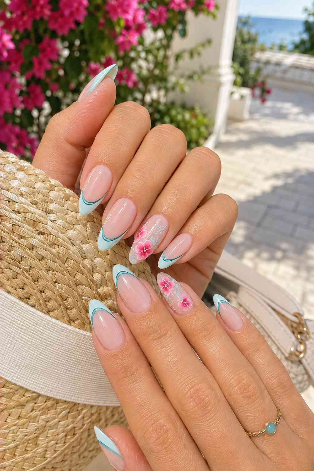 Sheer pink almond nails with pale teal French tips and delicate pink floral accent nails