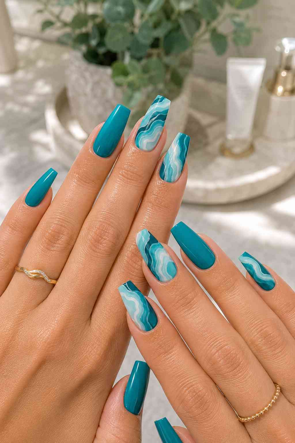 Long teal coffin nails with glossy solid teal polish and blue, teal, and white marble accent nails