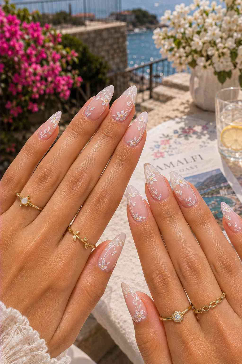 Sheer almond nails with a continuous hand-painted white daisy vine